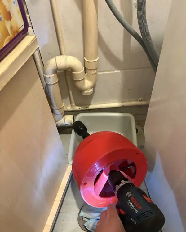 Débouchage au furet motorisé sous un lavabo
